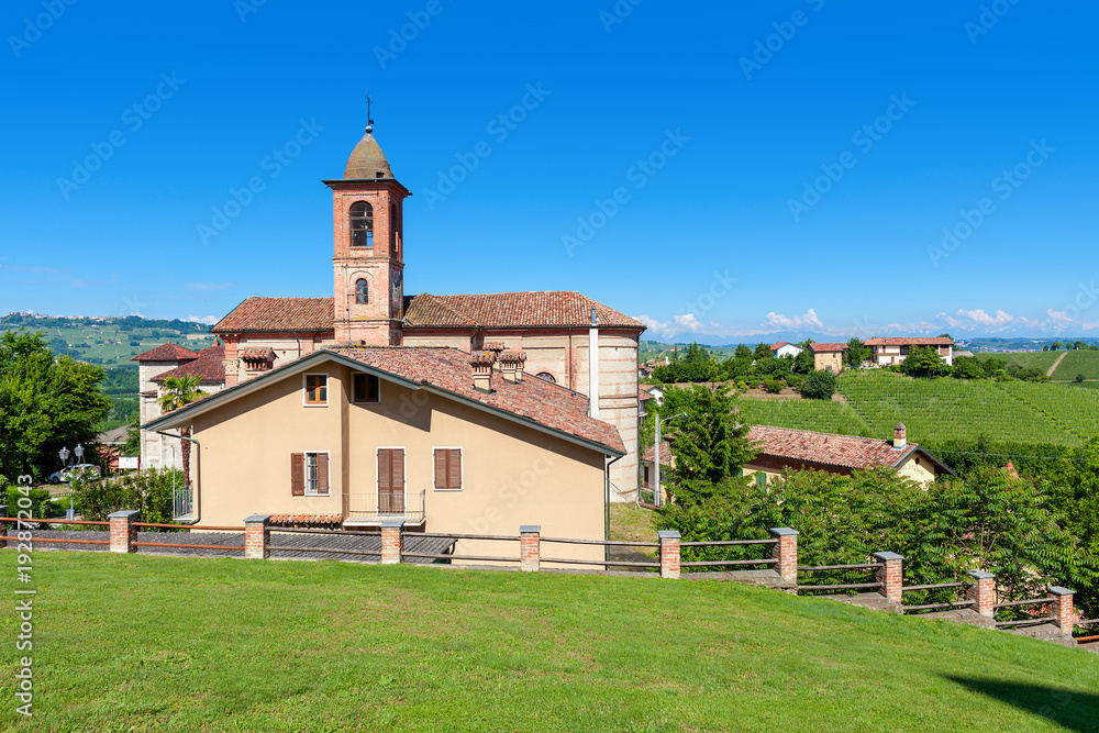 Small parish church on green lawn in Italy.