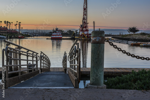 Dawn light reflected in marina water at end of gangway ramp. photo