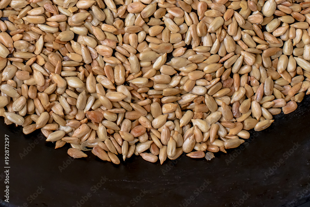 Obraz premium Roasted sunflower seeds in a black skillet