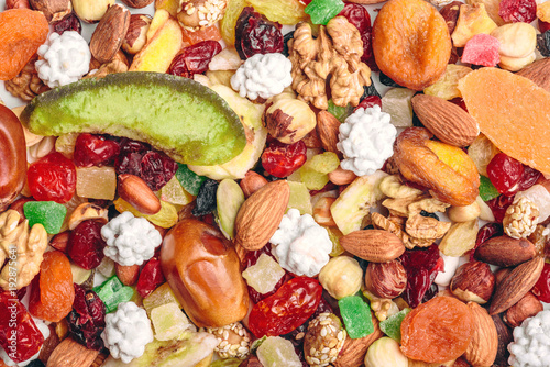 Tasty sweet mix dried fruits colorful background. A set of textures of nuts, legumes and dried fruits. © dmytro_khlystun