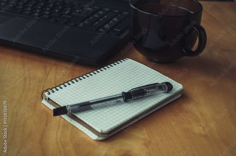 blank white notebook with pen and laptop on a background blank white notebook with pen and laptop on a background