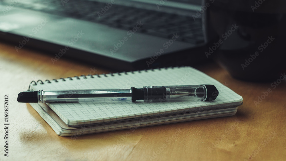 blank white notebook with pen and laptop on a background blank white notebook with pen and laptop on a background