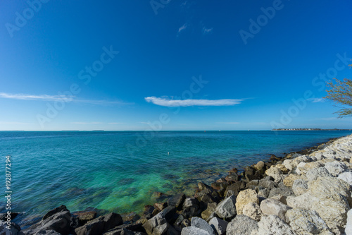 USA, Florida, Blue clean clear ocean water at key west behind white rocks © Simon