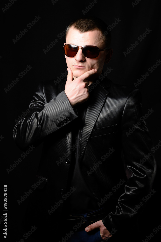 Studio portrait of a young guy with a short haircut in brown sunglasses Studio portrait of a young guy with a short haircut in brown sunglasses