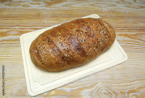 Freshly baked bread with sesame on a white plate. 