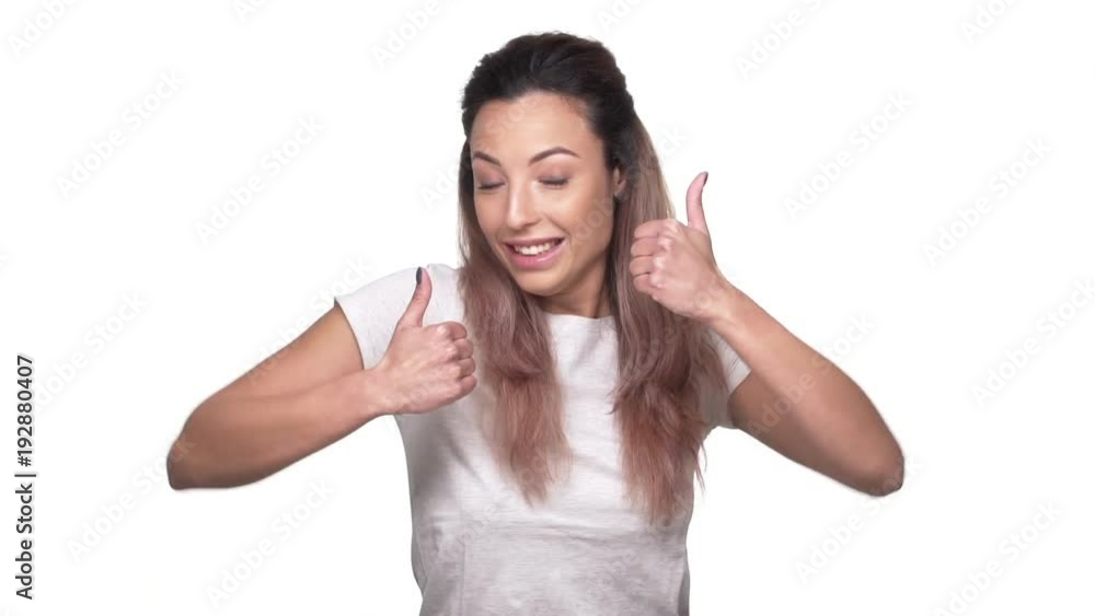Portrait of happy woman with dyed hair appearing on camera with thumbs up and smile, over white background slow motion. Concept of emotions Portrait of happy woman with dyed hair appearing on camera with thumbs up and smile, over white background slow motion. Concept of emotions