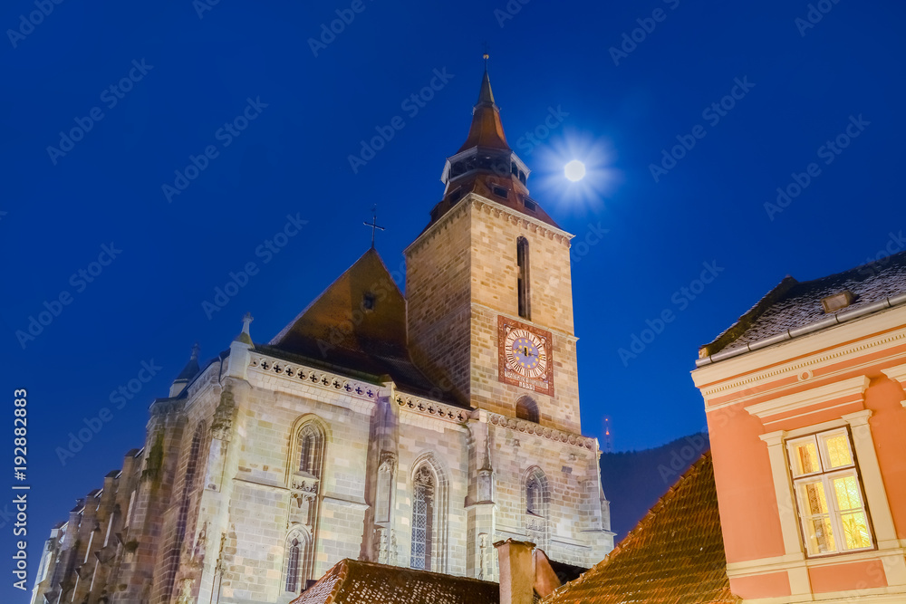 Fototapeta premium Night scene with the famous Black Church and the full moon on the sky in Brasov, Romania