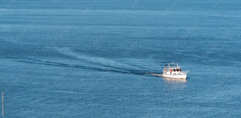 Small boat on the sea or on the river. Blue water with small waves Small boat on the sea or on the river. Blue water with small waves