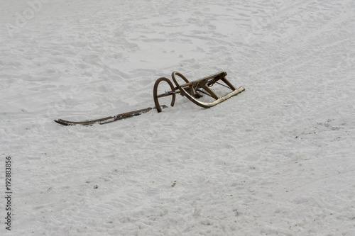 Broken snow sledge. Already useless sled standing alone in the snow.