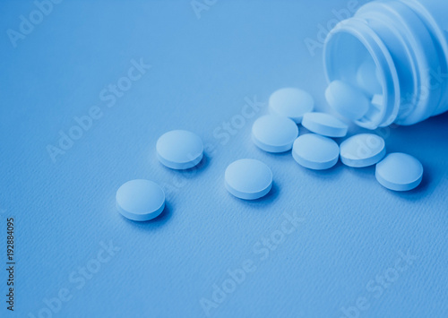 Белые таблетки на голубом фоне, витамины