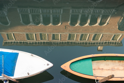 Zwei Boote vor einer Wasserspiegelung eines Palastes