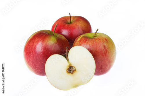 Four apples on a white background. One cut in half.