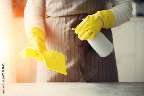 Woman in yellow rubber protective gloves wiping dust and dirty. Cleaning concept, banner, copy space