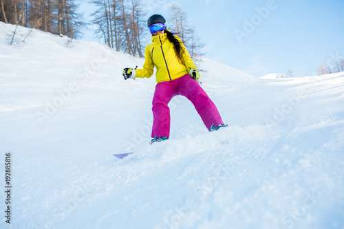 Image of sports woman in helmet and snowboarding mask from snowy slope with trees