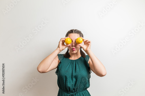Pretty girl makes sour face as she holds lemons © jev