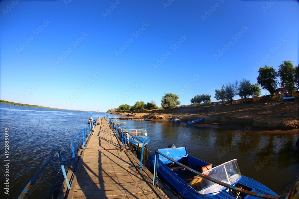 wooden pier with boats on the Volga river