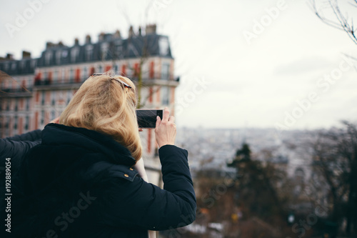 Donna bionda fotografa con smartphone dall'alto photo