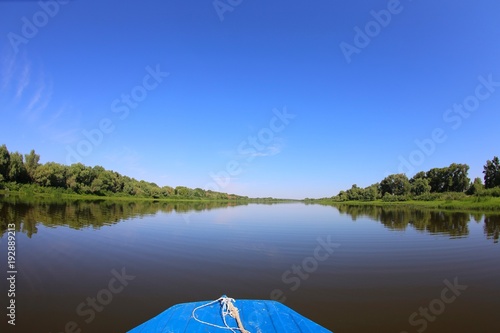 nose of a motor boat against a calm river and blue sky
