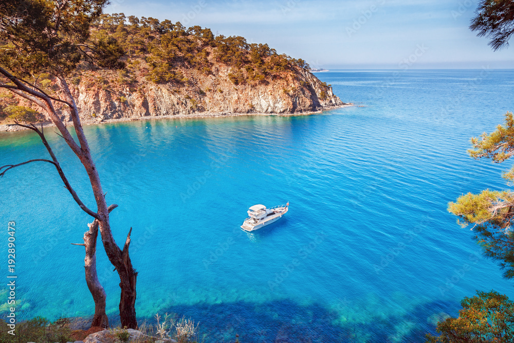 Naklejka premium Malownicza sceneria wybrzeża Turcji na Morzu Śródziemnym. Samotny luksusowy biały jacht w niesamowitej zatoce. Tło wakacje letnie. Lokalizacja Antalya Turcja.