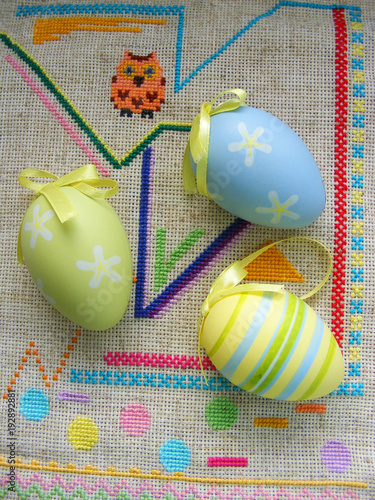 Easter eggs on embroidery canvas background photo