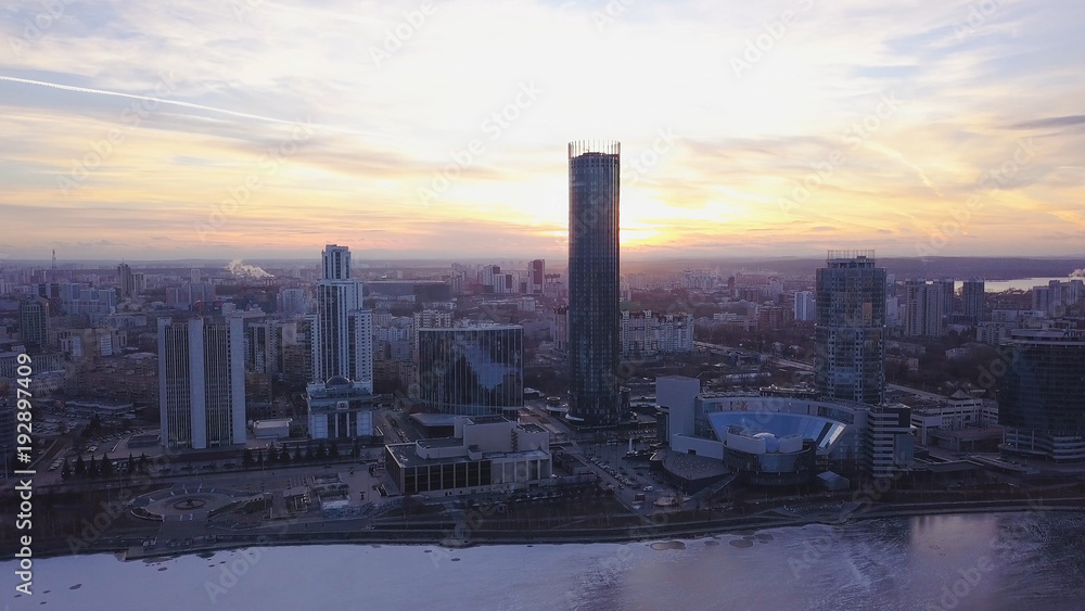 Sunset in megapolis. Clip. Beautiful cityscape with top view on skyscrapers. Top view of a sunset on the background of a skyscraper