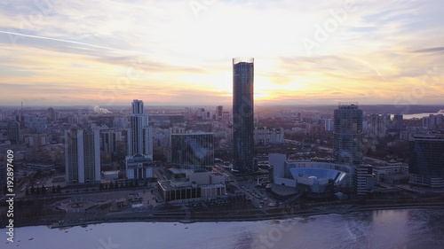 Sunset in megapolis. Clip. Beautiful cityscape with top view on skyscrapers. Top view of a sunset on the background of a skyscraper