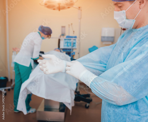 Group of surgeons in operating room with surgery equipment.