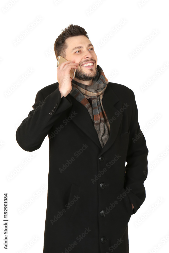 Fototapeta premium Young man talking on phone against white background. Ready for winter vacation
