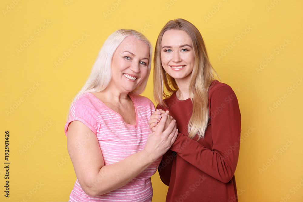 Young daughter and mother on color background Young daughter and mother on color background