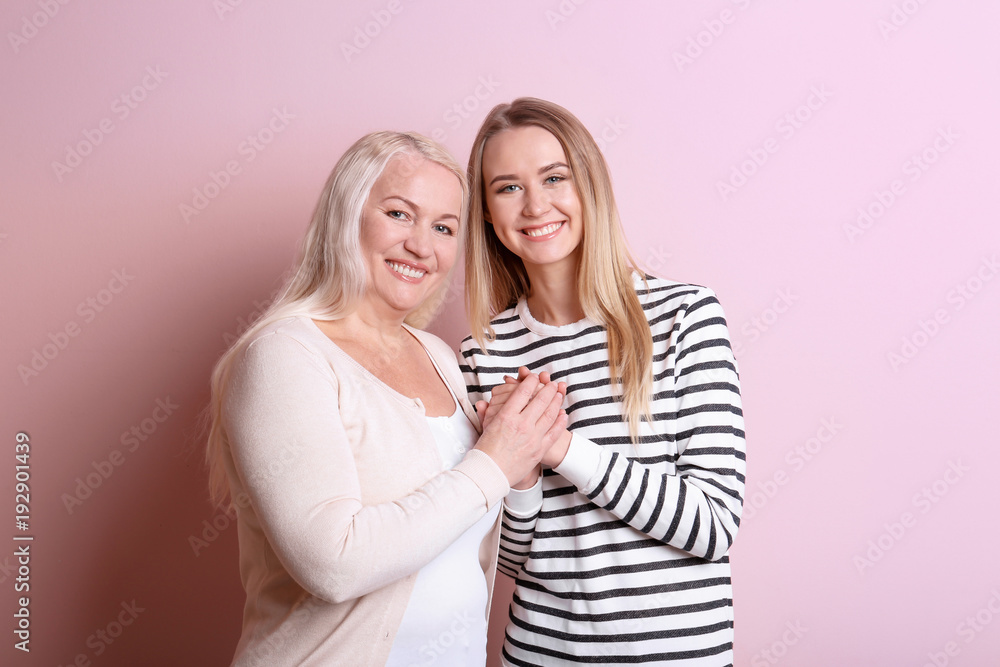 Young daughter and mother on color background Young daughter and mother on color background