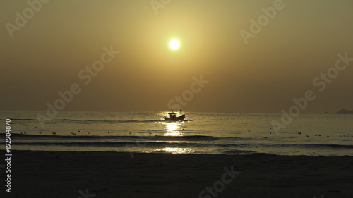 Fishing boat departing at sunrise