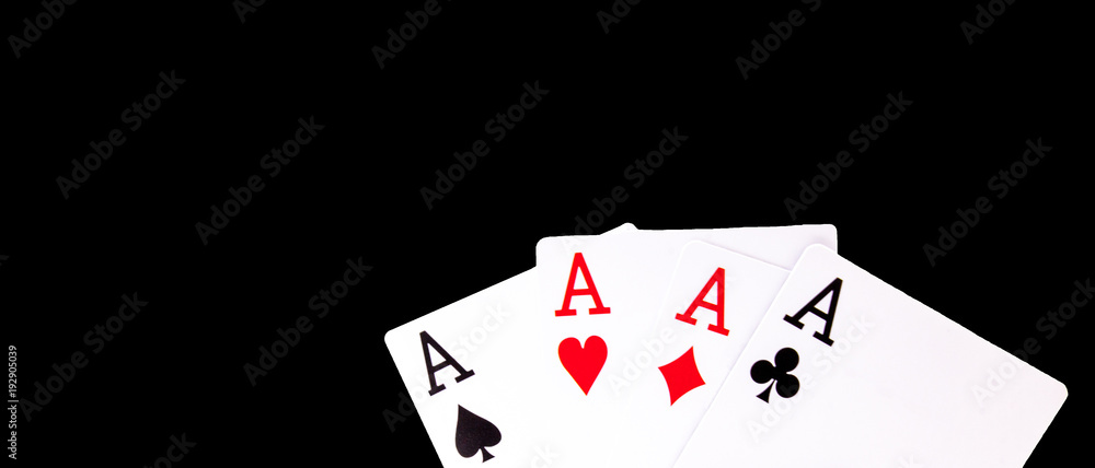 A winning poker hand of four aces playing cards suits on black background