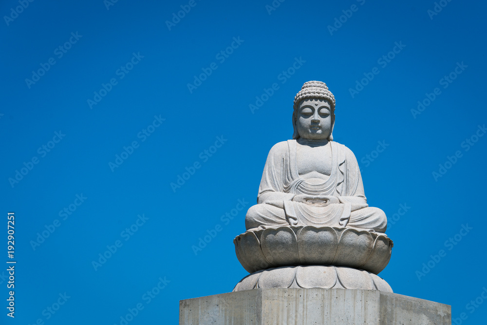 Stone Budda statue in front of a clear blue sky in Australia Stone Budda statue in front of a clear blue sky in Australia