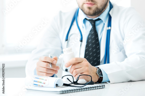 Doctor writes out the pills to the patient