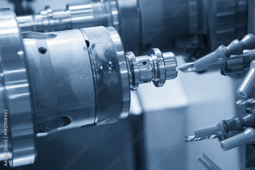 The CNC lathe machine cutting the metal shaft with the drill tool. The CNC lathe machine cutting the metal shaft with the drill tool.