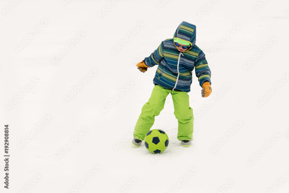 A young lady in a blue ski suit plays football with children in the snow. Yellow sled, sunglasses, bright clothes. Girl happy outdoors. Fun winter vacation for the whole family. Green soccer ball A young lady in a blue ski suit plays football with children in the snow. Yellow sled, sunglasses, bright clothes. Girl happy outdoors. Fun winter vacation for the whole family. Green soccer ball