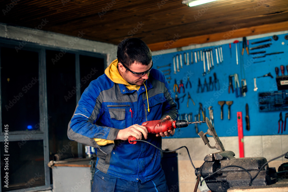 Man using power drill in workshop Man using power drill in workshop