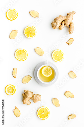Cup of ginger tea near ginger root on white background top view pattern