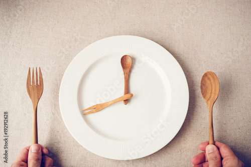 white plate with spoon and fork, Intermittent fasting concept, ketogenic diet, weight loss, food crisis photo