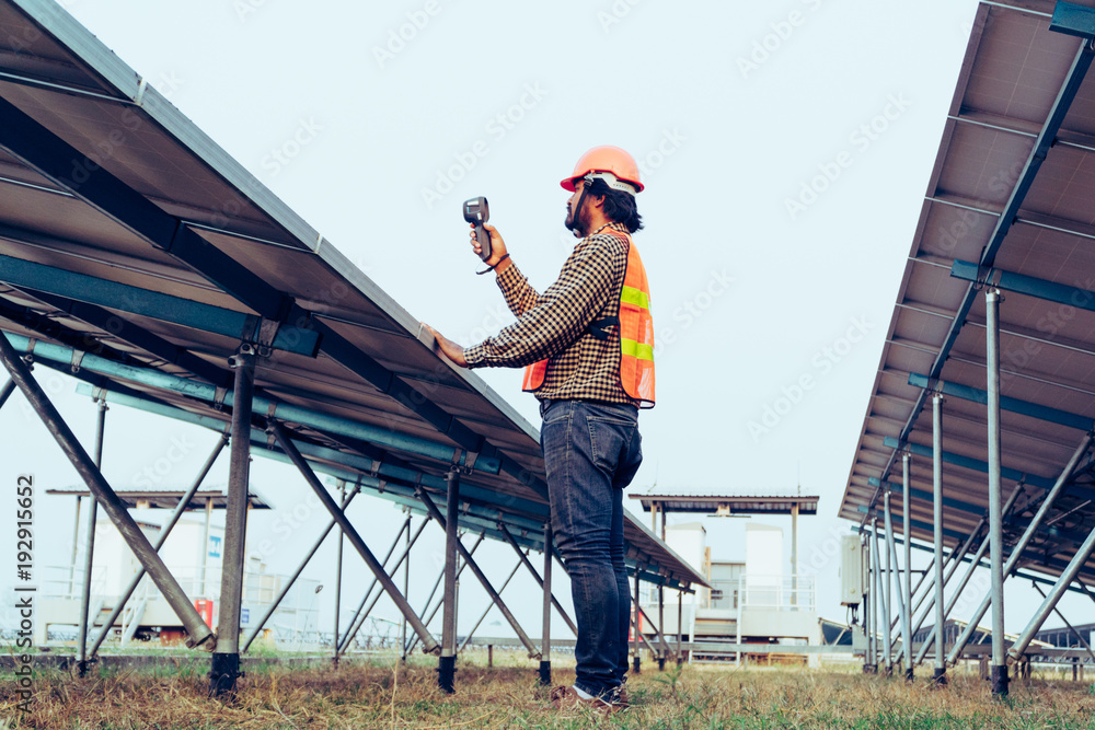 solar power plant to innovation of green energy; engineer or electrician working on checking and maintenance equipment at solar power plant