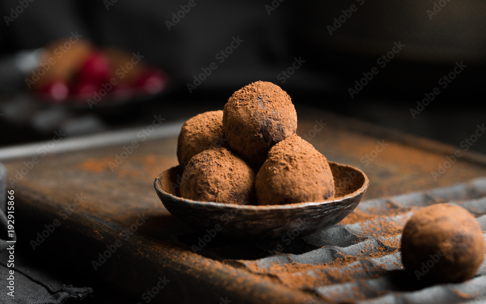Chocolate truffle. Dark chocolate and cherry candy sprinkled with cocoa on a dark wooden background in rustic style. Atmospheric food photo. Homemade fresh energy balls. Chocolate truffle. Dark chocolate and cherry candy sprinkled with cocoa on a dark wooden background in rustic style. Atmospheric food photo. Homemade fresh energy balls.