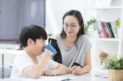 Asian boy with mother teaching and learning your homework at home