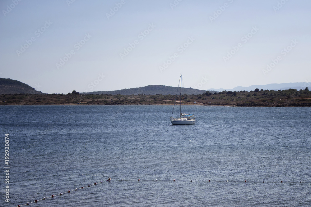 View of a sailboat (yacht), Aegean sea and landscape in Cunda (Alibey) island.