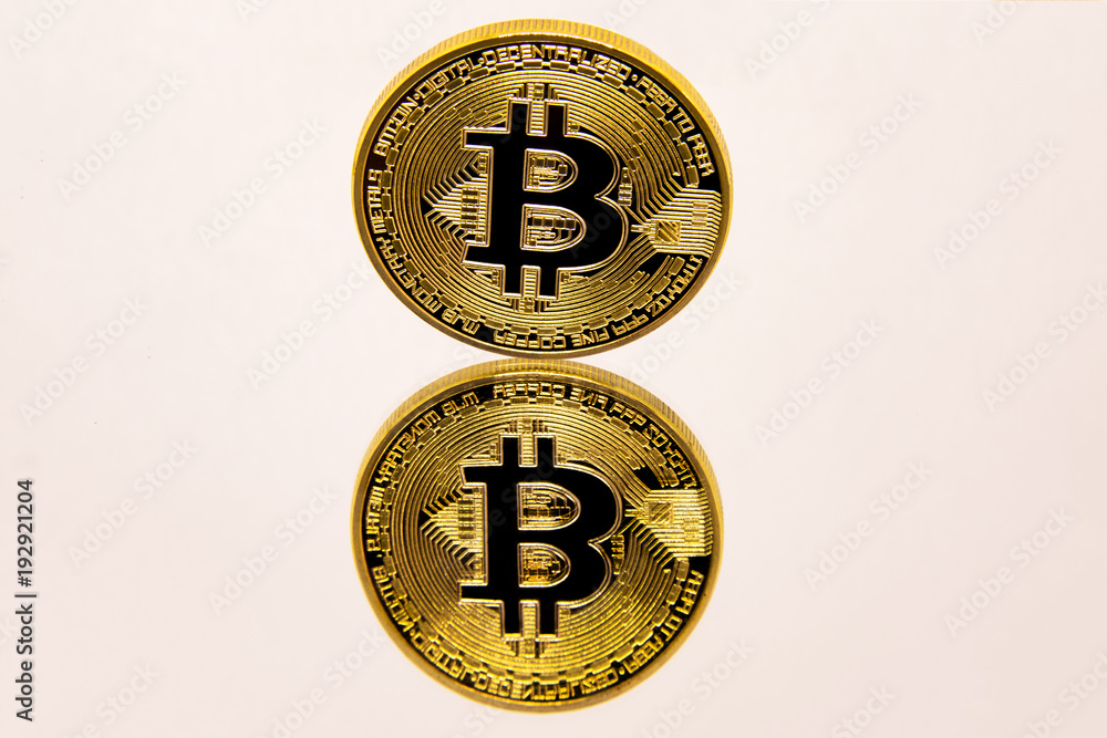 Conceptual representation of a gold bitcoin on a white mirror surface.