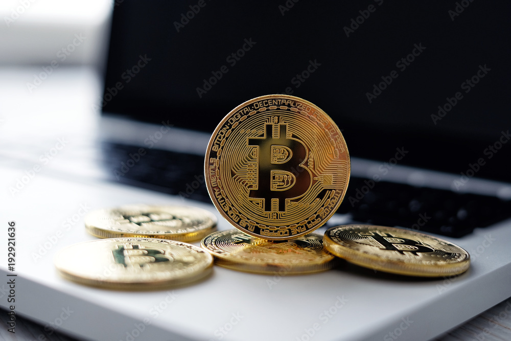 Golden Bitcoin coins on the laptop keyboard. Trading concept