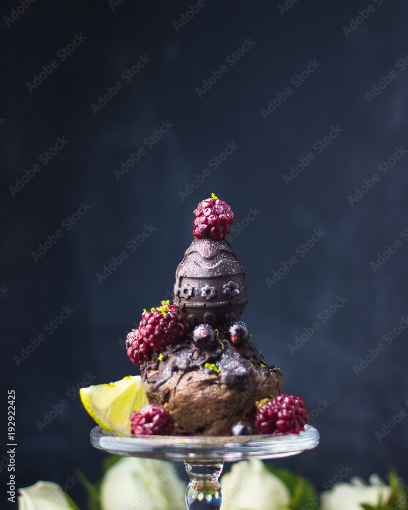 dark chocolate egg for Easter on cupcake with lime, blackberry and currant
