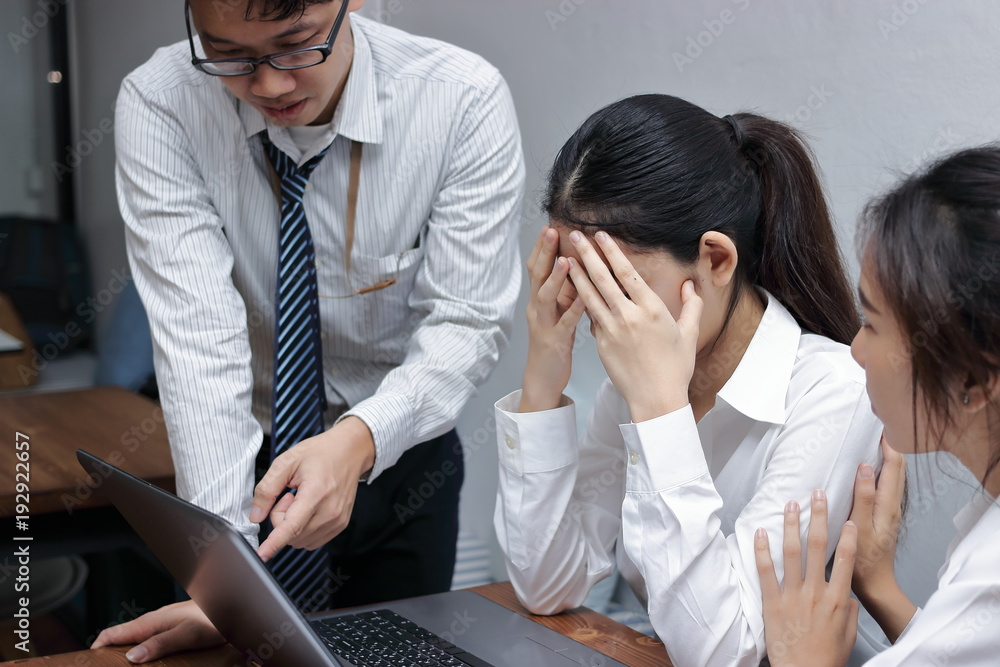 Fototapeta premium Anxious depressed young Asian business women are being blamed with boss in workplace.