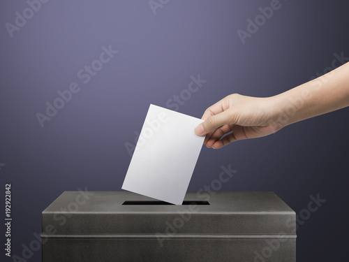 Hand holding ballot paper for election vote concept background.