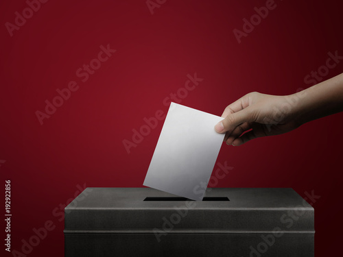 Valokuva Hand holding ballot paper for election vote concept background.