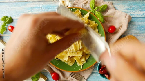 Warm colors footage: hard cheese is grated on the beautiful plate of fresh pappardelle photo